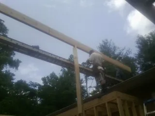 Carpenter setting a ridge beam over a new addition frame — Ice Dam Removal by Roofing Brothers in Clarksville