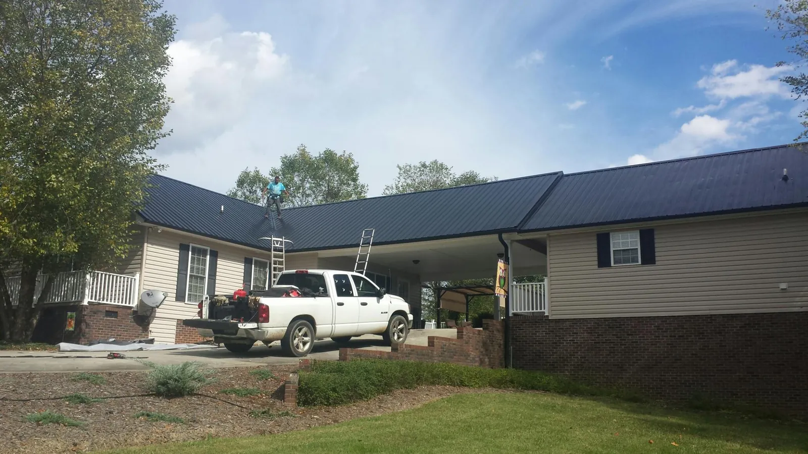 Black metal roof over a home and attached breezeway with ladders set in Clarksville